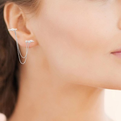 femme qui porte un bijou d'oreille original, bague d'oreille, chaine double et motif argent et zircon