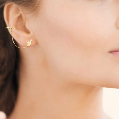 Boucles d'oreilles en plaqué or jaune 18 carats portées, mettant en avant la chaîne fine qui épouse l'oreill