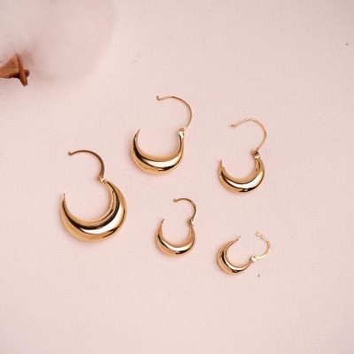 Gros plan boucles d'oreilles or jaune massif, créoles polies, collection L'Éclat Luni