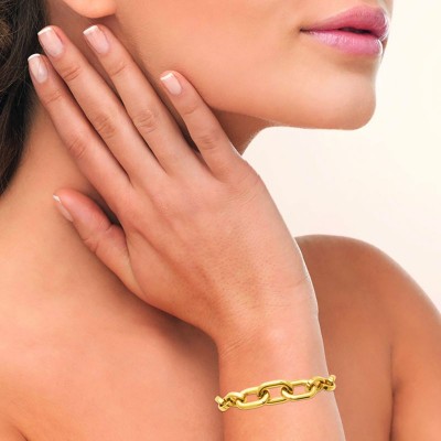 bracelet maillons larges en acier doré porté au poignet