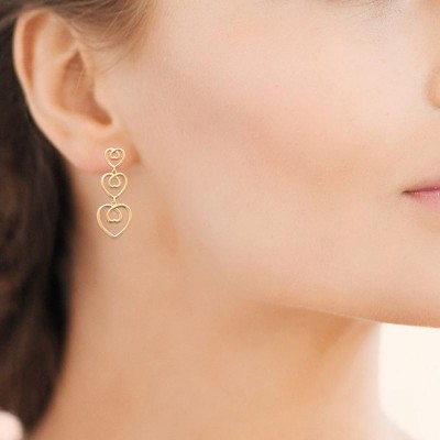 femme porte longues boucles d'oreilles pendantes coeur